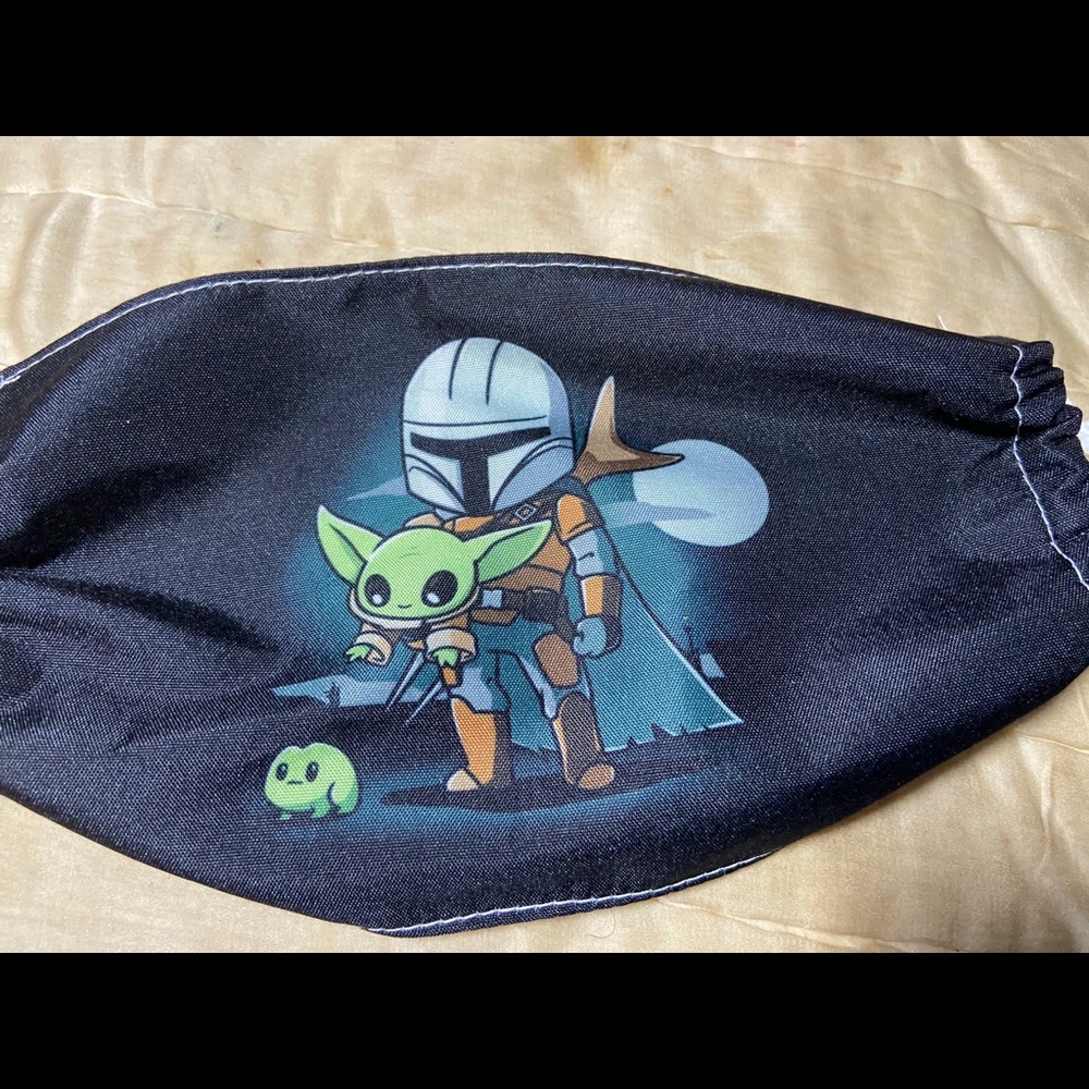 Mando holding baby Yoda Mask